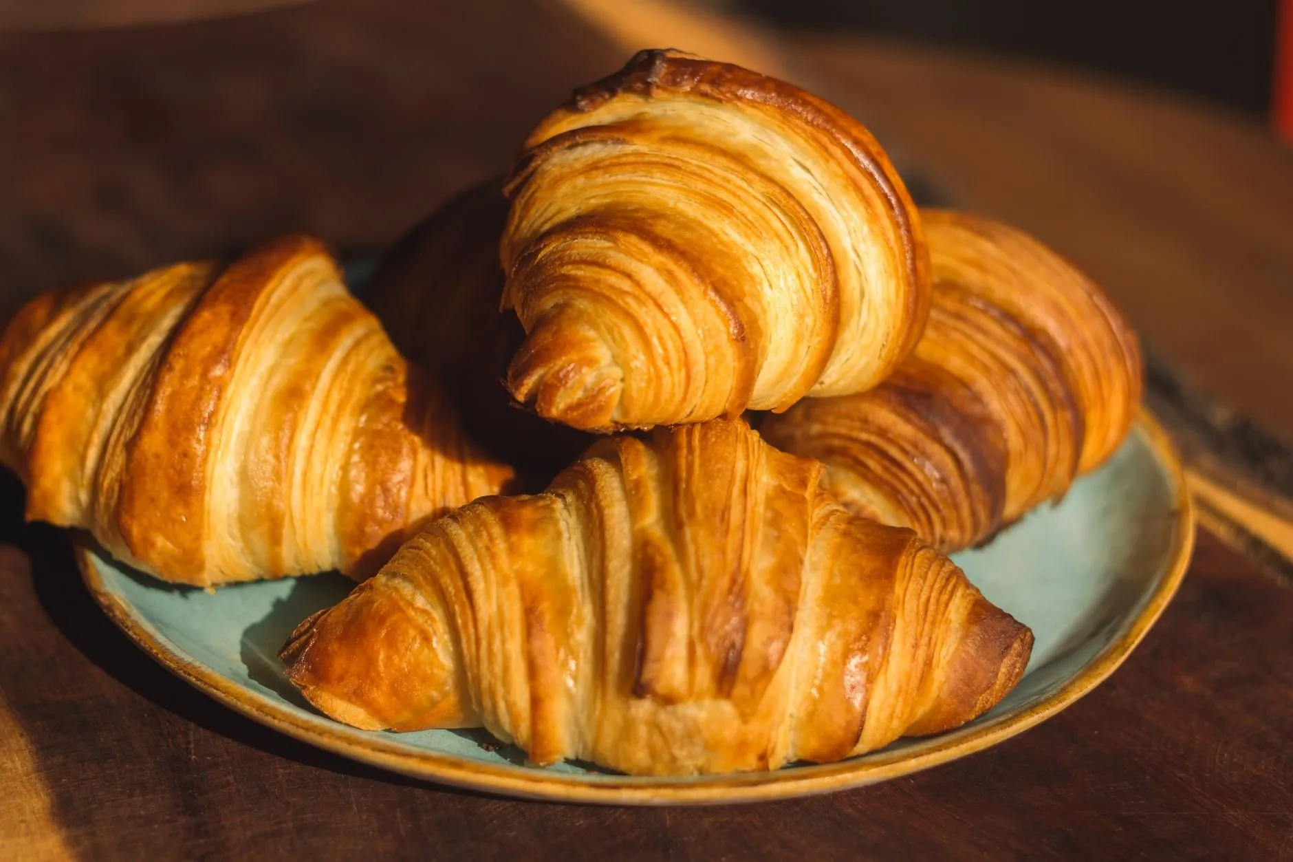 A plate of golden butter croissants with deep flaky layers